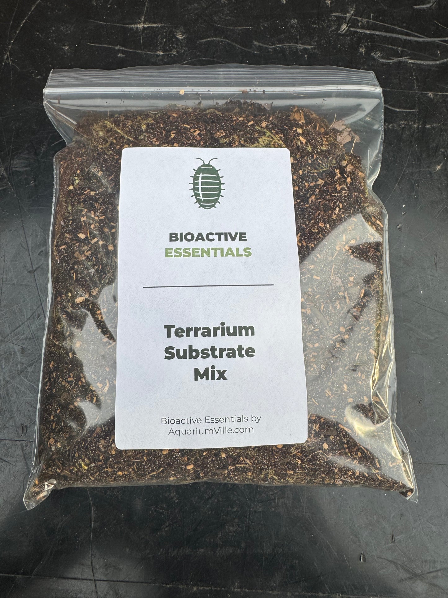 Bag of Bioactive Essentials Terrarium Substrate Mix displayed on a dark background. The clear resealable bag reveals a premium blend of soil, bark, leaf matter, and moss, with a clean product label suitable for bioactive terrariums, vivariums, and isopod habitats.