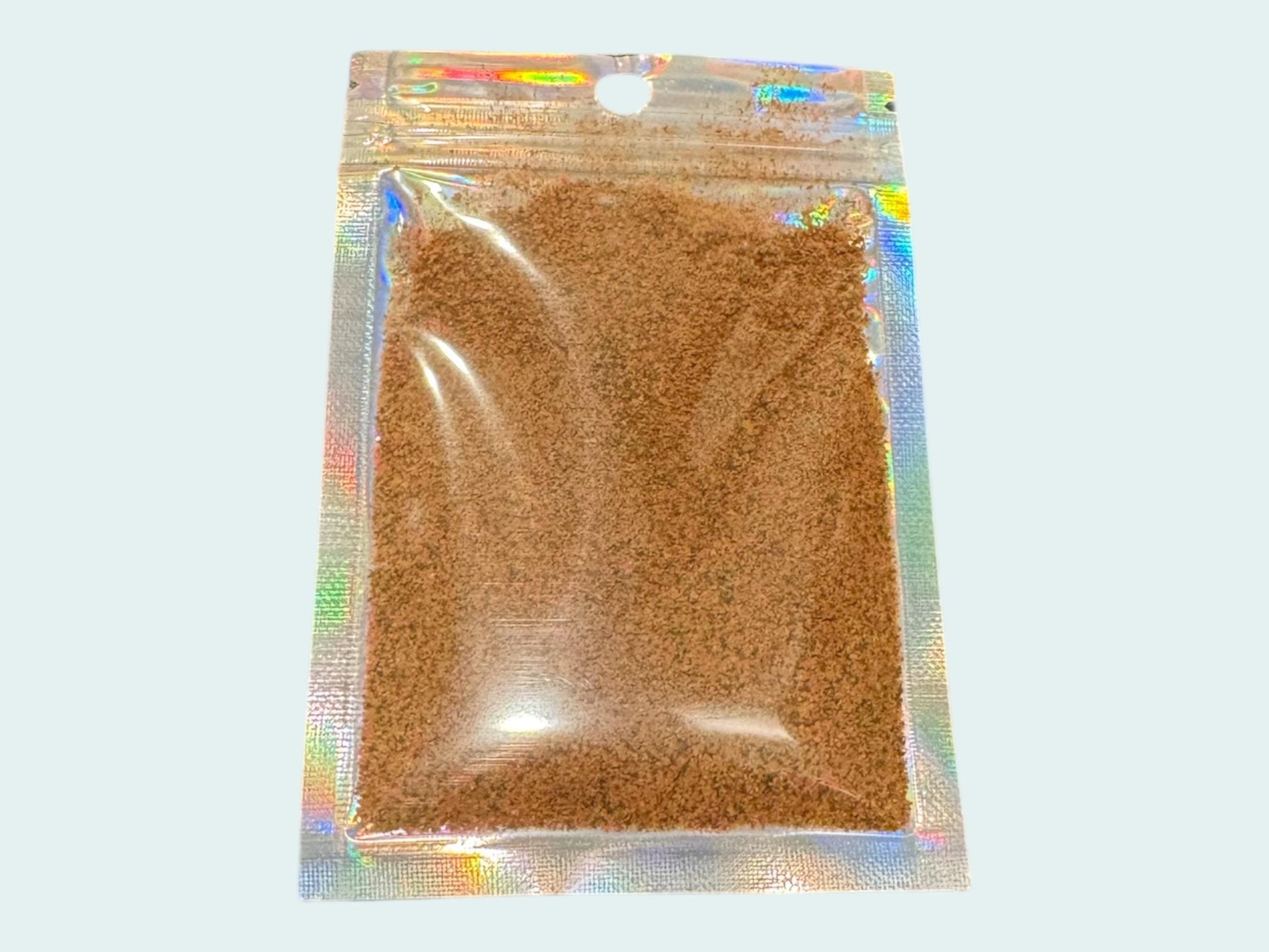 May include: A small, clear plastic bag with a silver iridescent finish. The bag contains powdered fish food