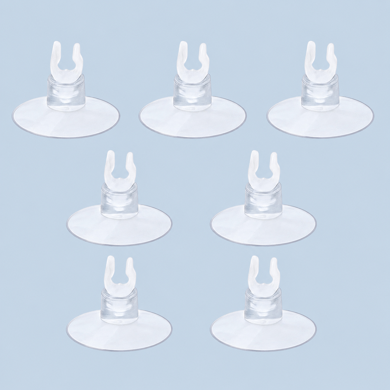 Seven clear aquarium suction cup clips arranged on a light blue background, commonly used for holding airline tubing, heaters, or aquarium accessories in fish tanks.