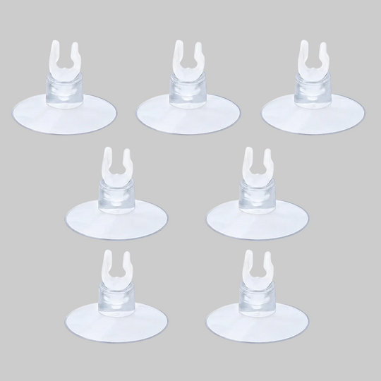 Seven clear aquarium suction cup clips arranged on a light blue background, commonly used for holding airline tubing, heaters, or aquarium accessories in fish tanks.