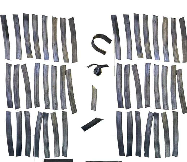 A collection of black metal strips, some are straight and some are curved. The strips are arranged in two groups, one on the left and one on the right. The strips are all the same size and shape. they are used as weights to keep live aquatic plants from floating up.
