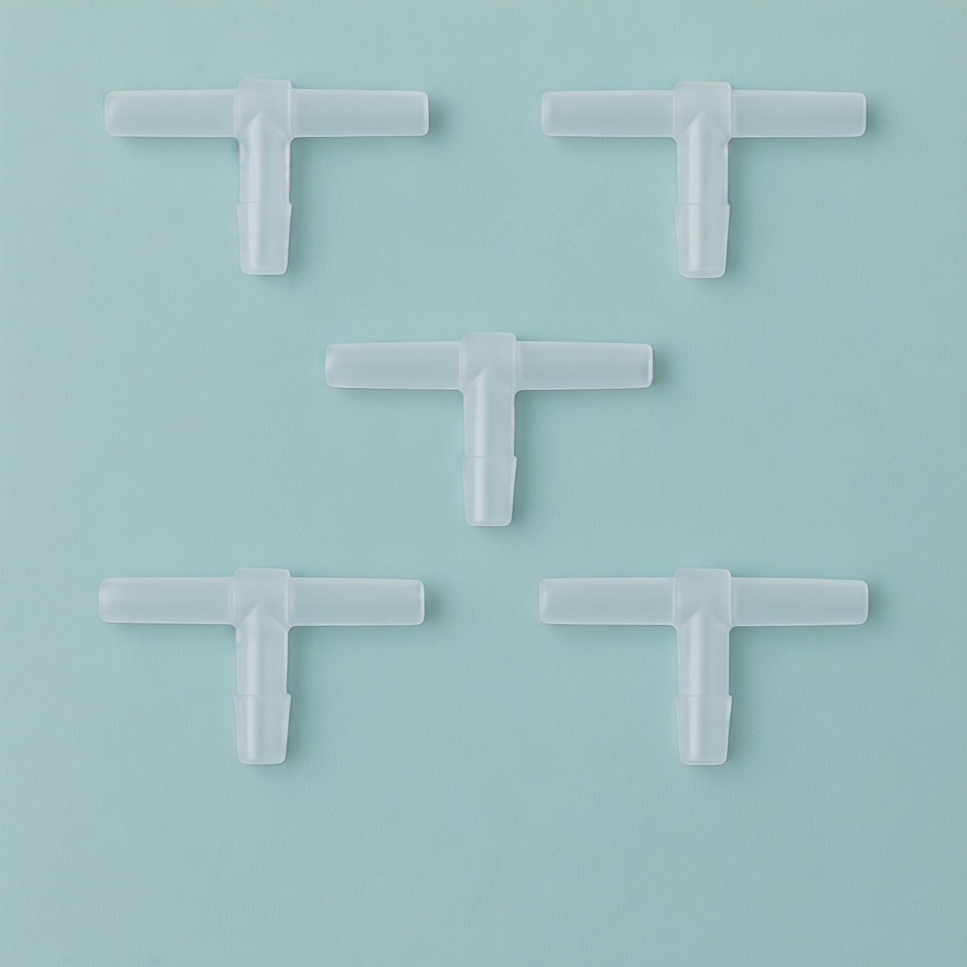 Five transparent T-shaped aquarium airline tubing connectors arranged in a dice-style pattern on an Aqua Mist background (#B7D8D2), shown in a clean, minimalist square composition with soft lighting for an Etsy product photo.