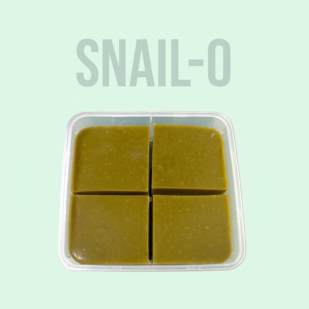 Square plastic container labeled “SNAIL-O” also sometimes spelled snell-o , is an aquatic snail food filled with greenish-brown gel food, neatly cut into four equal square portions, displayed on a soft mint green background.